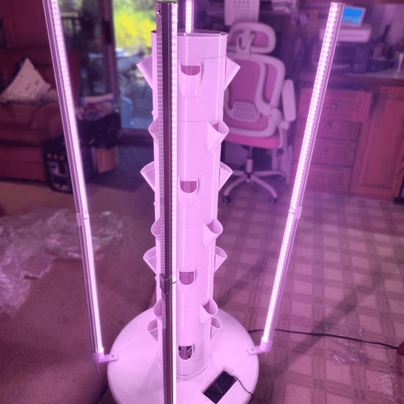 Compact vertical hydroponics setup featuring an installed grow light, perfect for urban farming.